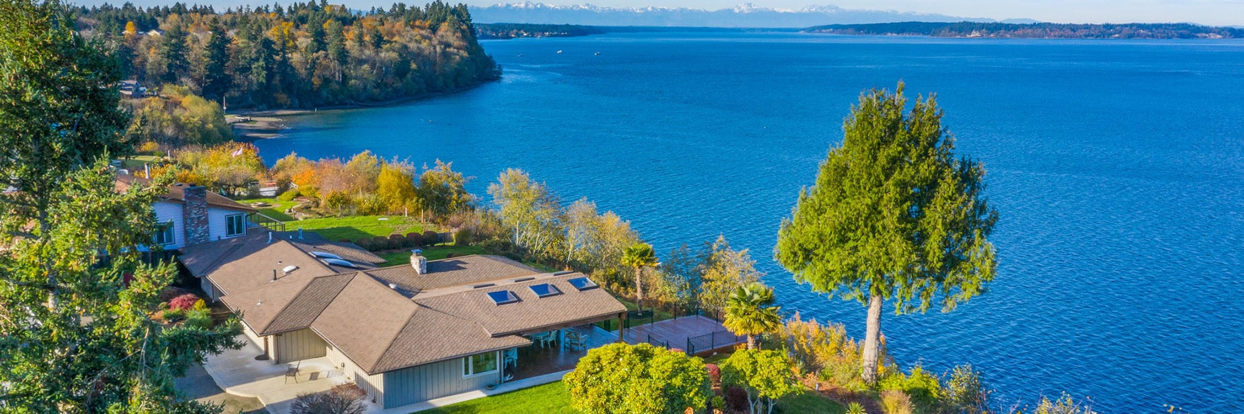 Waterfront home with scenic ocean view and trees.